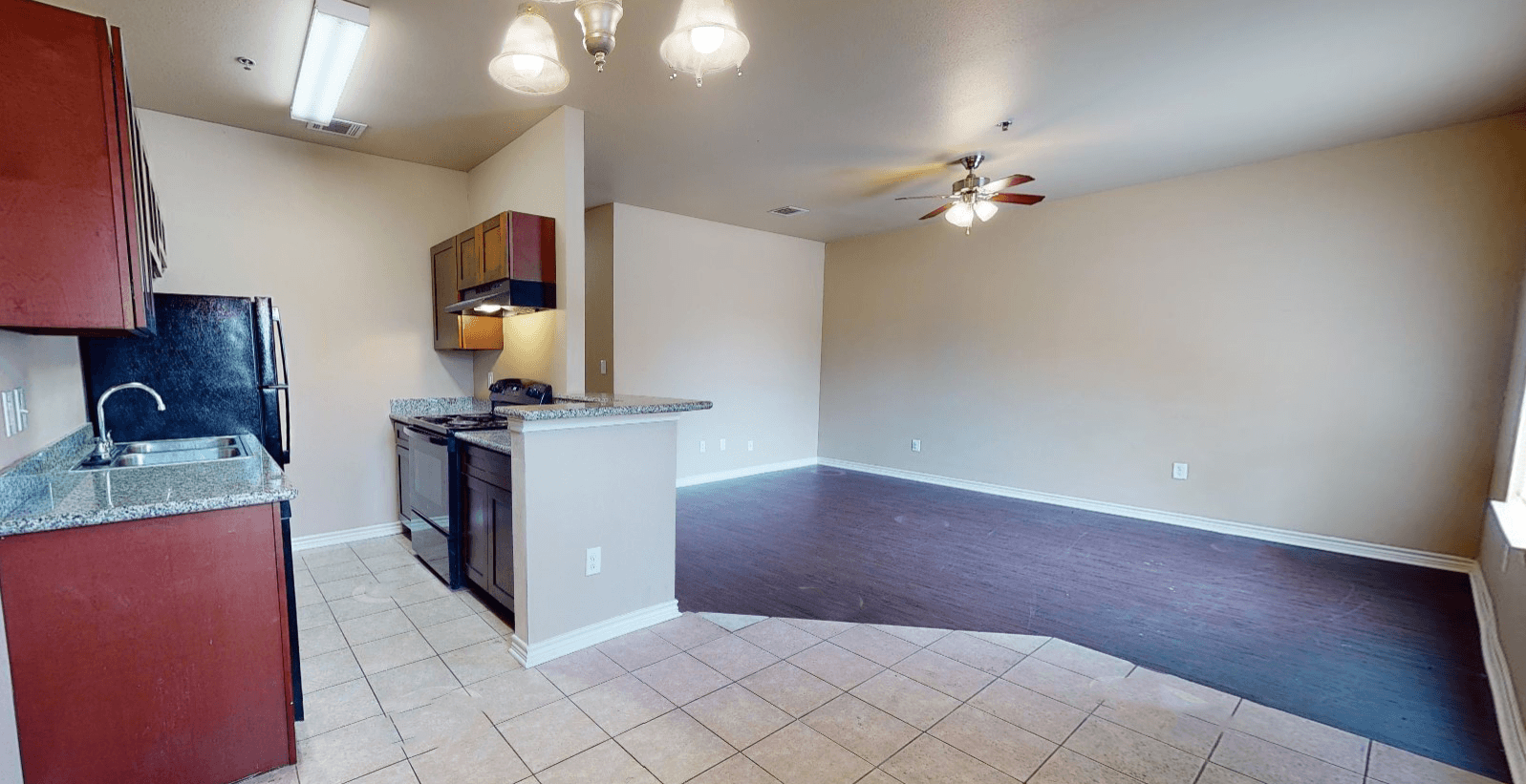 a kitchen and living room with a ceiling fan
